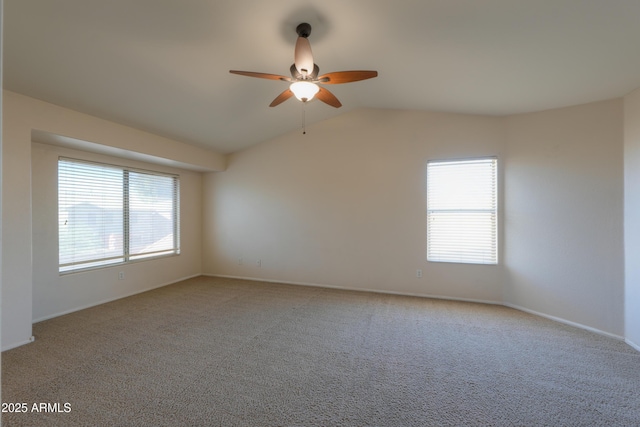 carpeted spare room featuring ceiling fan and vaulted ceiling