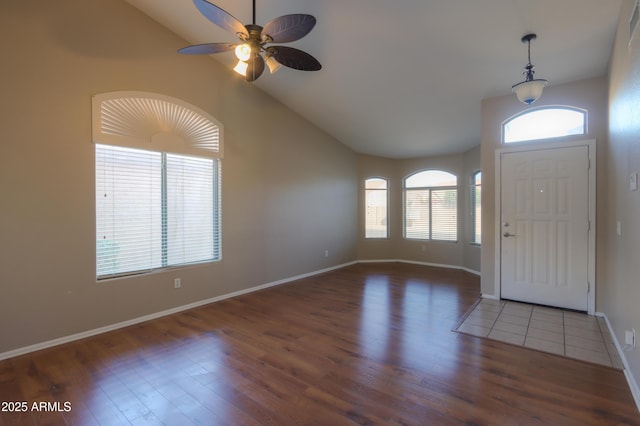 entrance foyer with ceiling fan, dark hardwood / wood-style flooring, a wealth of natural light, and high vaulted ceiling