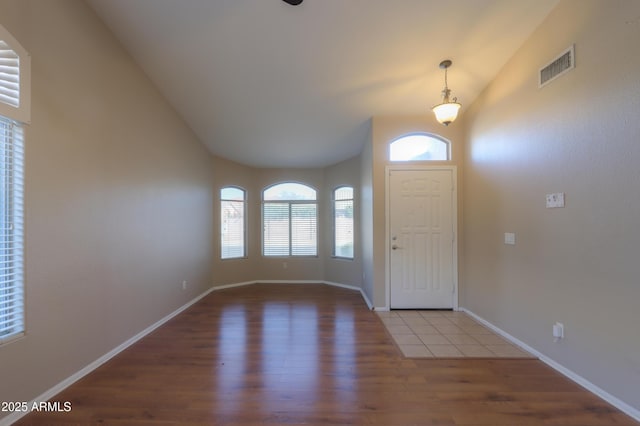 foyer with vaulted ceiling and hardwood / wood-style floors