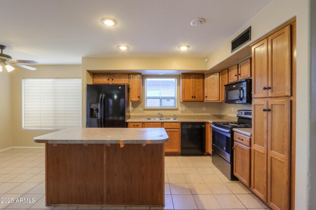 kitchen featuring light tile patterned floors, a kitchen island, sink, and black appliances