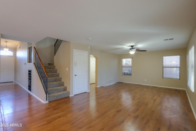 unfurnished living room featuring ceiling fan, a wealth of natural light, and hardwood / wood-style floors