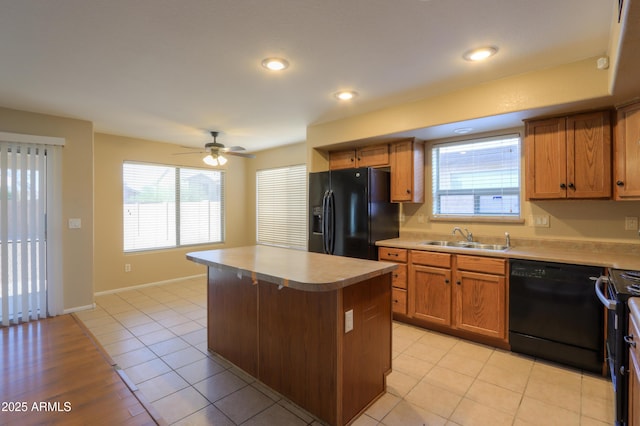 kitchen featuring ceiling fan, a center island, black appliances, sink, and light tile patterned floors