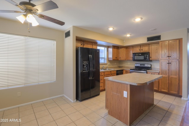 kitchen with ceiling fan, a center island, black appliances, sink, and light tile patterned floors