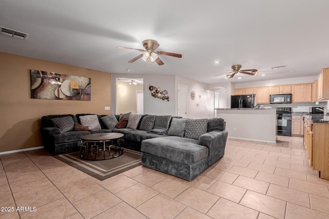 living area featuring light tile patterned floors, visible vents, and a ceiling fan