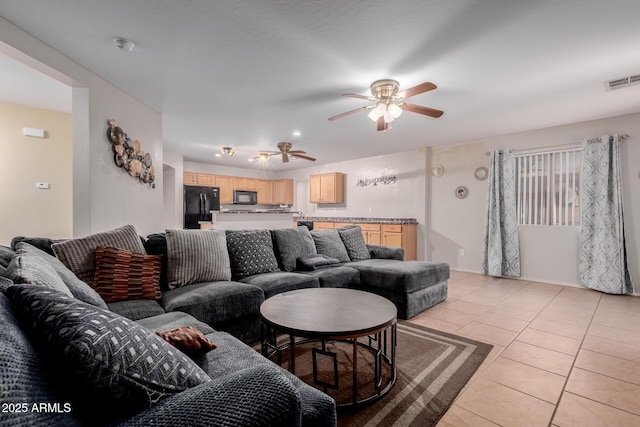 living area with visible vents, a ceiling fan, and light tile patterned flooring