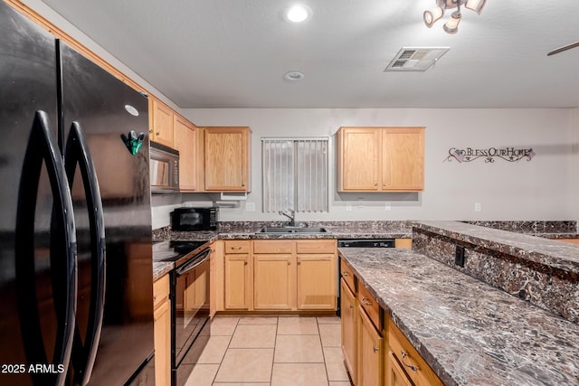 kitchen with visible vents, light brown cabinetry, black appliances, a sink, and light tile patterned flooring