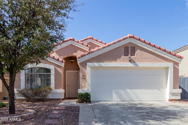 view of front of home with a garage, a tiled roof, concrete driveway, and stucco siding