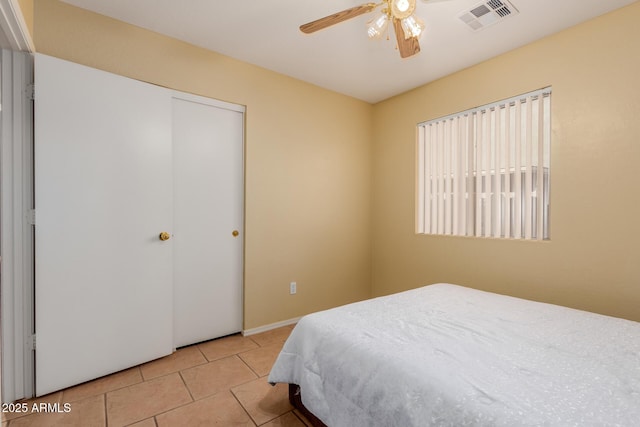 bedroom with a closet, visible vents, ceiling fan, and light tile patterned floors