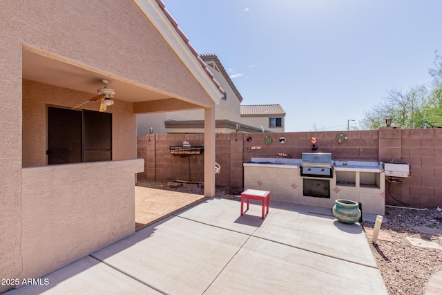 view of patio featuring fence private yard, exterior kitchen, grilling area, and a ceiling fan