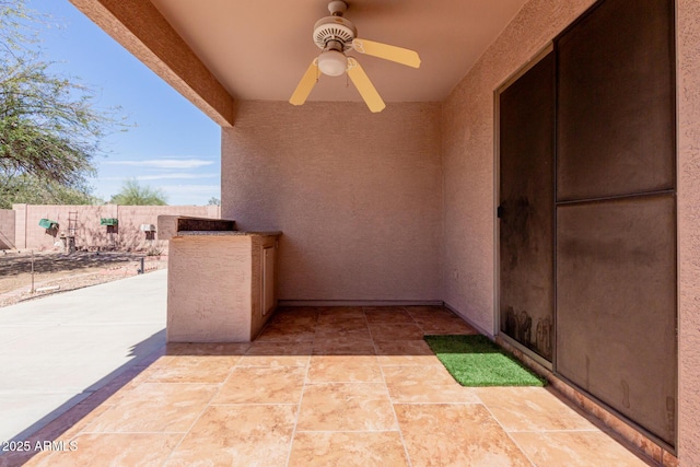 view of patio / terrace with fence and a ceiling fan