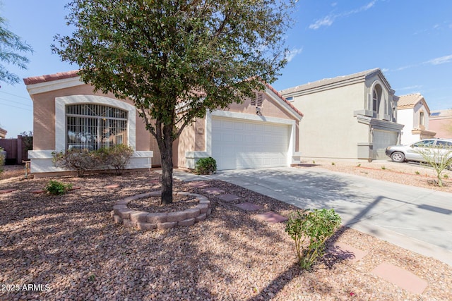 view of front of home featuring a garage, concrete driveway, a tile roof, and stucco siding