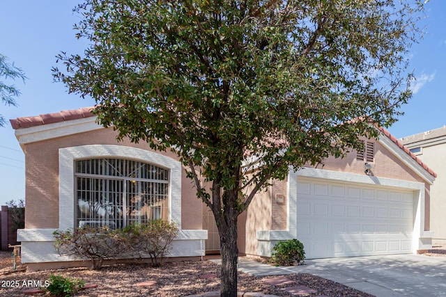 view of front of home featuring a garage, concrete driveway, a tiled roof, and stucco siding