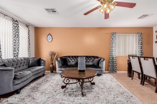 living room featuring light tile patterned floors, visible vents, and baseboards