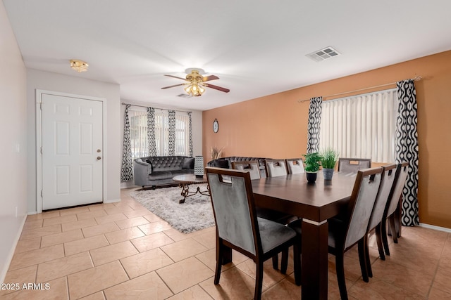 dining room featuring a ceiling fan, visible vents, baseboards, and light tile patterned floors