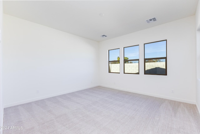 spare room featuring light colored carpet