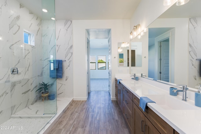 bathroom featuring oversized vanity, hardwood / wood-style floors, dual sinks, and walk in shower