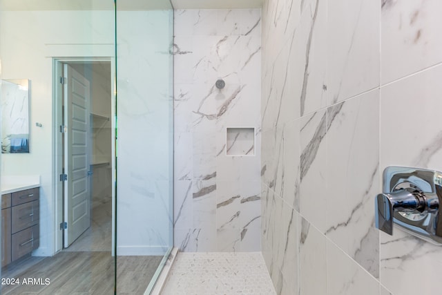 bathroom with vanity, hardwood / wood-style floors, and tiled shower