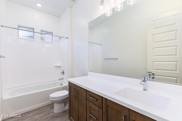 full bathroom featuring vanity, washtub / shower combination, hardwood / wood-style flooring, and toilet