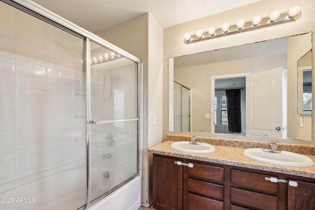 bathroom featuring vanity and bath / shower combo with glass door