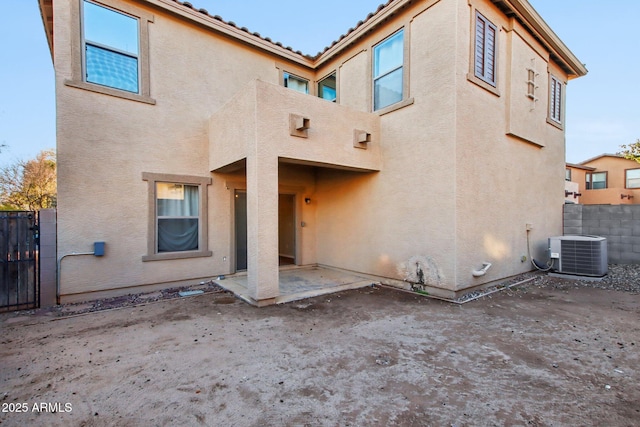 rear view of property featuring cooling unit and a patio area