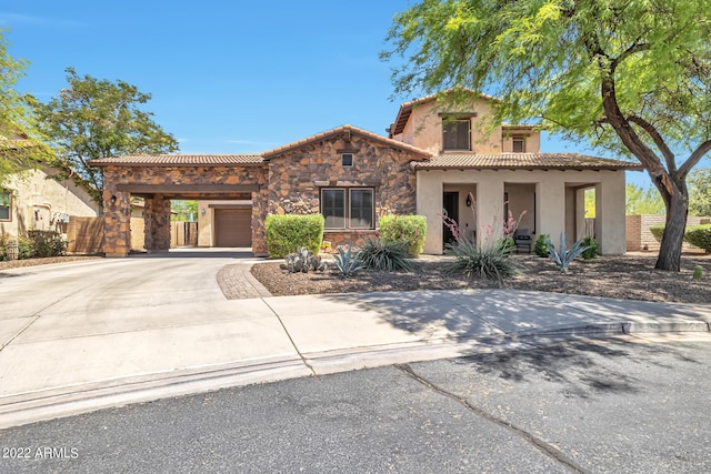 mediterranean / spanish-style home with fence, a garage, stone siding, driveway, and a tiled roof