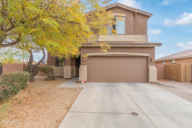 view of front of house with a tiled roof, fence, driveway, and stucco siding