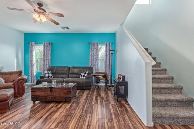 living room featuring stairs, wood finished floors, visible vents, and a healthy amount of sunlight