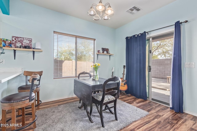 office space featuring an inviting chandelier, dark wood-type flooring, baseboards, and visible vents