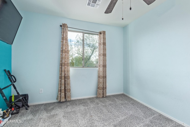 carpeted spare room featuring visible vents, baseboards, and a ceiling fan