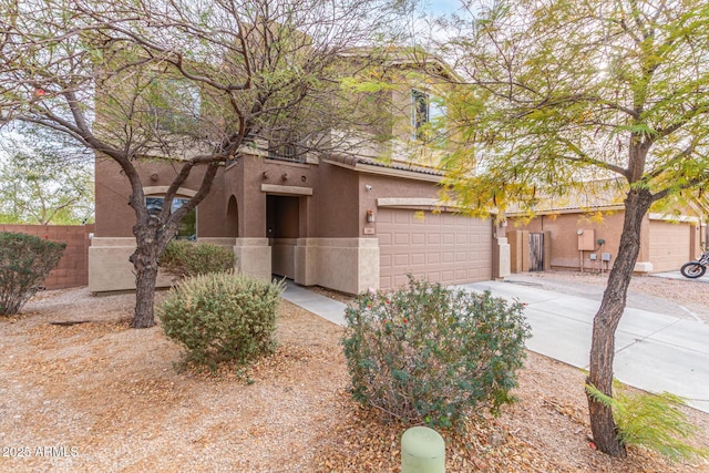 view of front of home featuring fence, a garage, driveway, and stucco siding