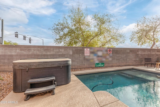 view of pool featuring a patio area, a hot tub, and a fenced backyard