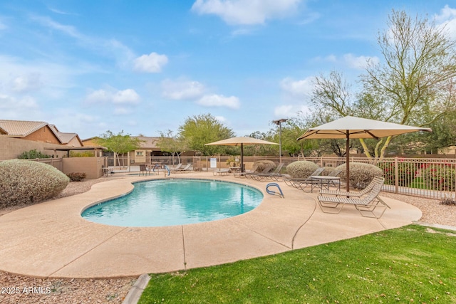 pool with a patio and fence