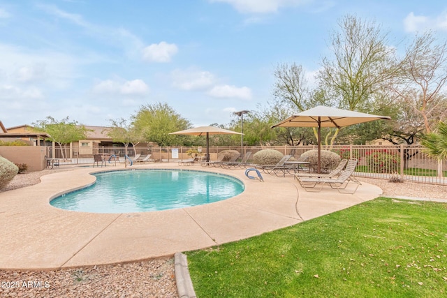 community pool with a patio area and fence