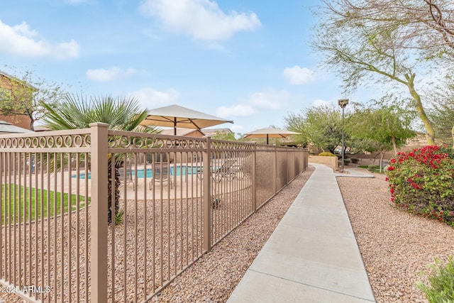 surrounding community featuring a swimming pool, a patio area, and fence