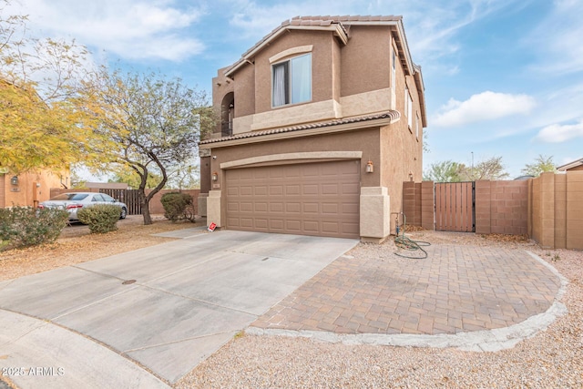 view of front facade featuring stucco siding, fence, driveway, and a gate