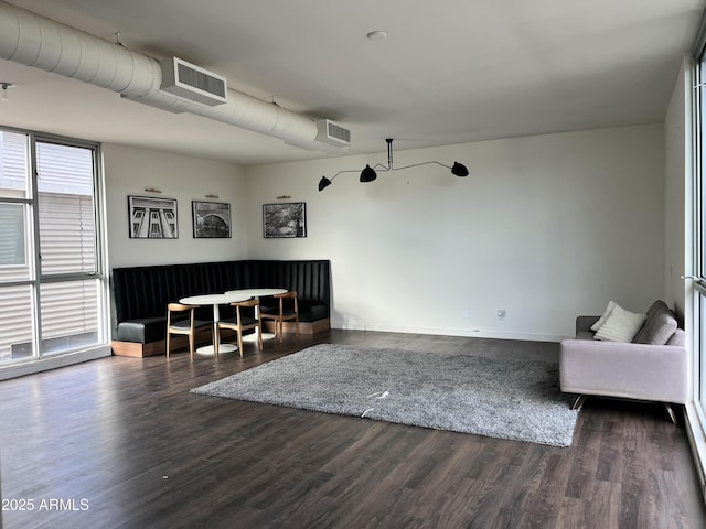 living area with baseboards, wood finished floors, and visible vents