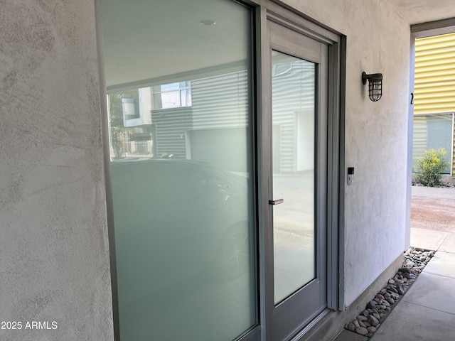 doorway to property featuring stucco siding