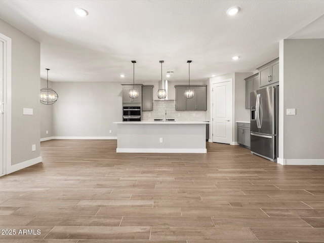 17809 W Elm St, Goodyear, AZ 85395 - kitchen featuring stainless steel fridge, gray cabinetry, wall chimney range hood, a sink, and recessed lighting