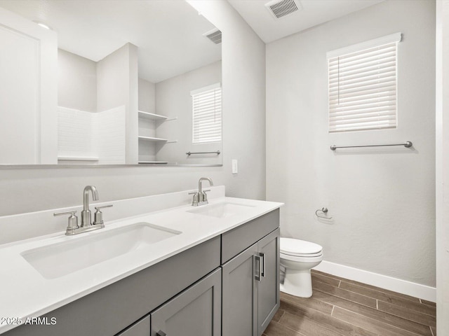 17809 W Elm St, Goodyear, AZ 85395 - bathroom featuring wood finished floors, toilet, baseboards, and double vanity