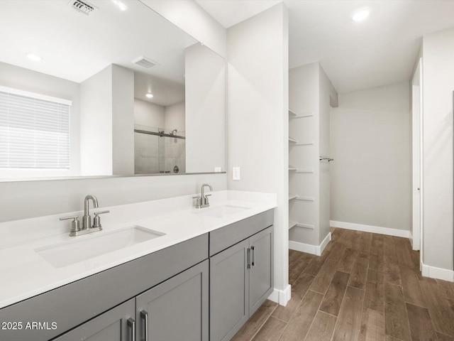 17809 W Elm St, Goodyear, AZ 85395 - full bath with baseboards, a stall shower, wood finished floors, double vanity, and recessed lighting