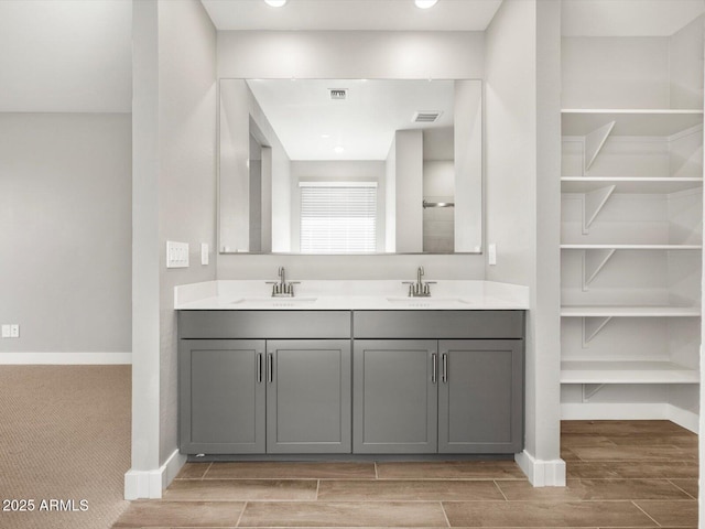 17809 W Elm St, Goodyear, AZ 85395 - bathroom featuring wood finish floors, double vanity, and baseboards