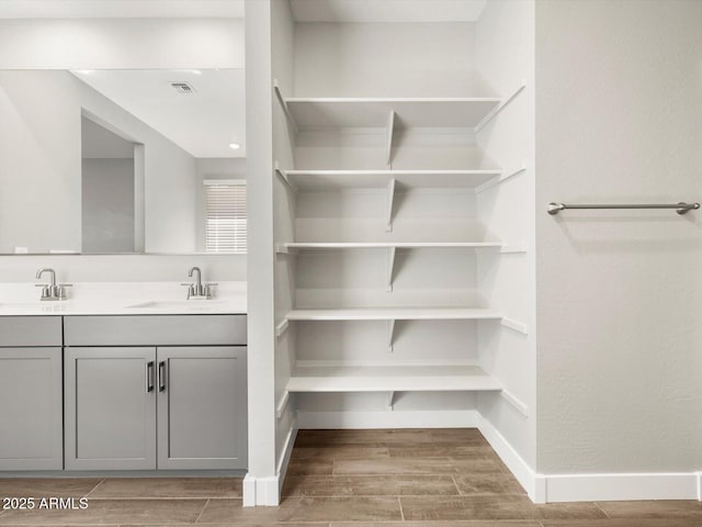 17809 W Elm St, Goodyear, AZ 85395 - bathroom featuring wood finished floors, double vanity, and baseboards