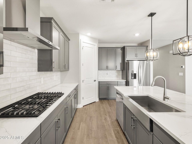 17809 W Elm St, Goodyear, AZ 85395 - kitchen with stainless steel appliances, wall chimney range hood, gray cabinets, a sink, and recessed lighting