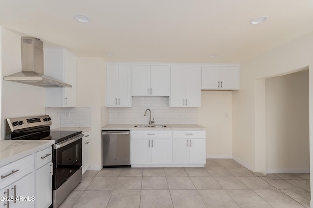 kitchen with white cabinetry, sink, decorative backsplash, stainless steel appliances, and wall chimney exhaust hood