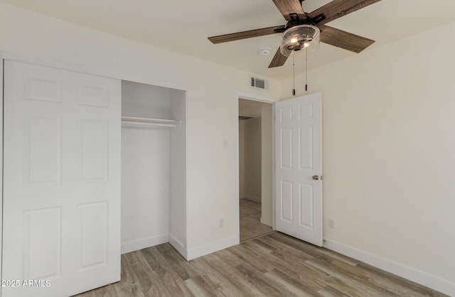 unfurnished bedroom featuring ceiling fan, a closet, and light hardwood / wood-style flooring