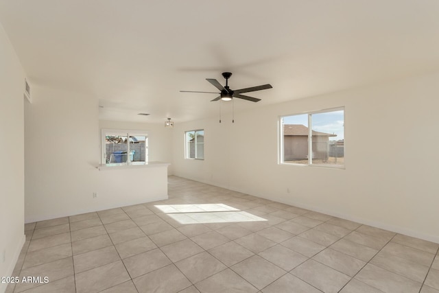 tiled spare room with ceiling fan and a healthy amount of sunlight