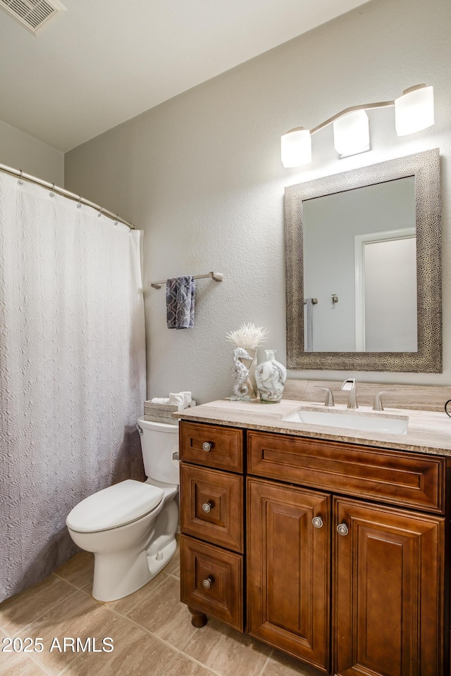 bathroom featuring tile patterned flooring, vanity, and toilet