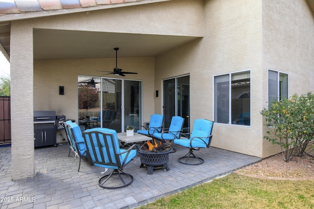 view of patio / terrace with a fire pit, ceiling fan, and a grill