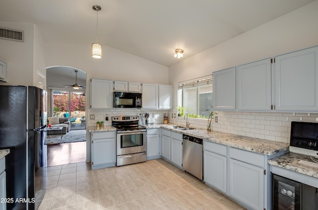 kitchen featuring ceiling fan, beverage cooler, black appliances, decorative light fixtures, and lofted ceiling