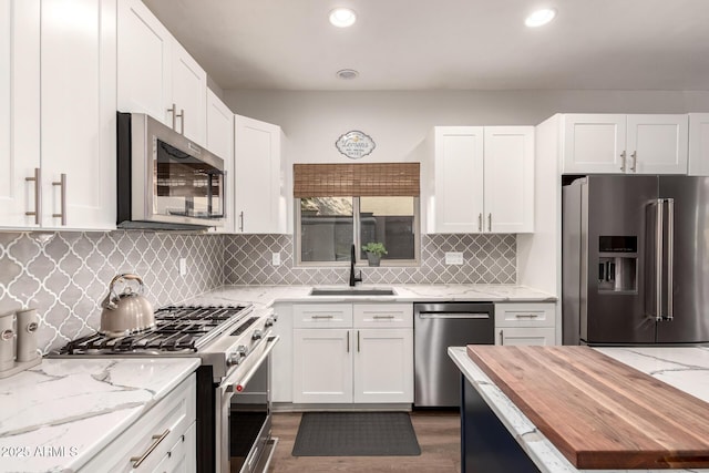 40807 N Barnum Way, Anthem, AZ 85086 - kitchen featuring stainless steel appliances, a sink, wooden counters, white cabinets, and tasteful backsplash